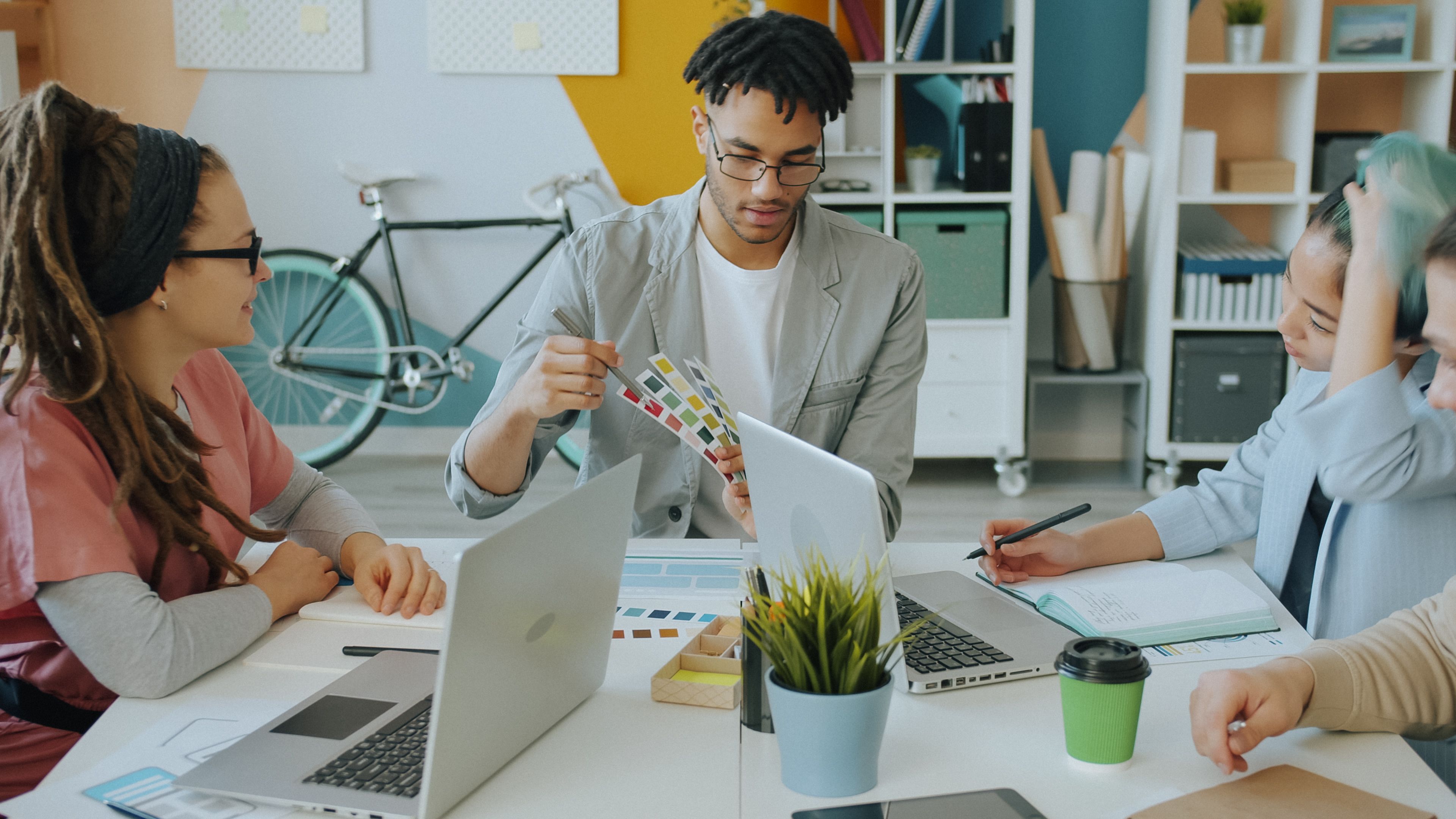 Diverse creative team discussing color samples during a meeting in a modern office