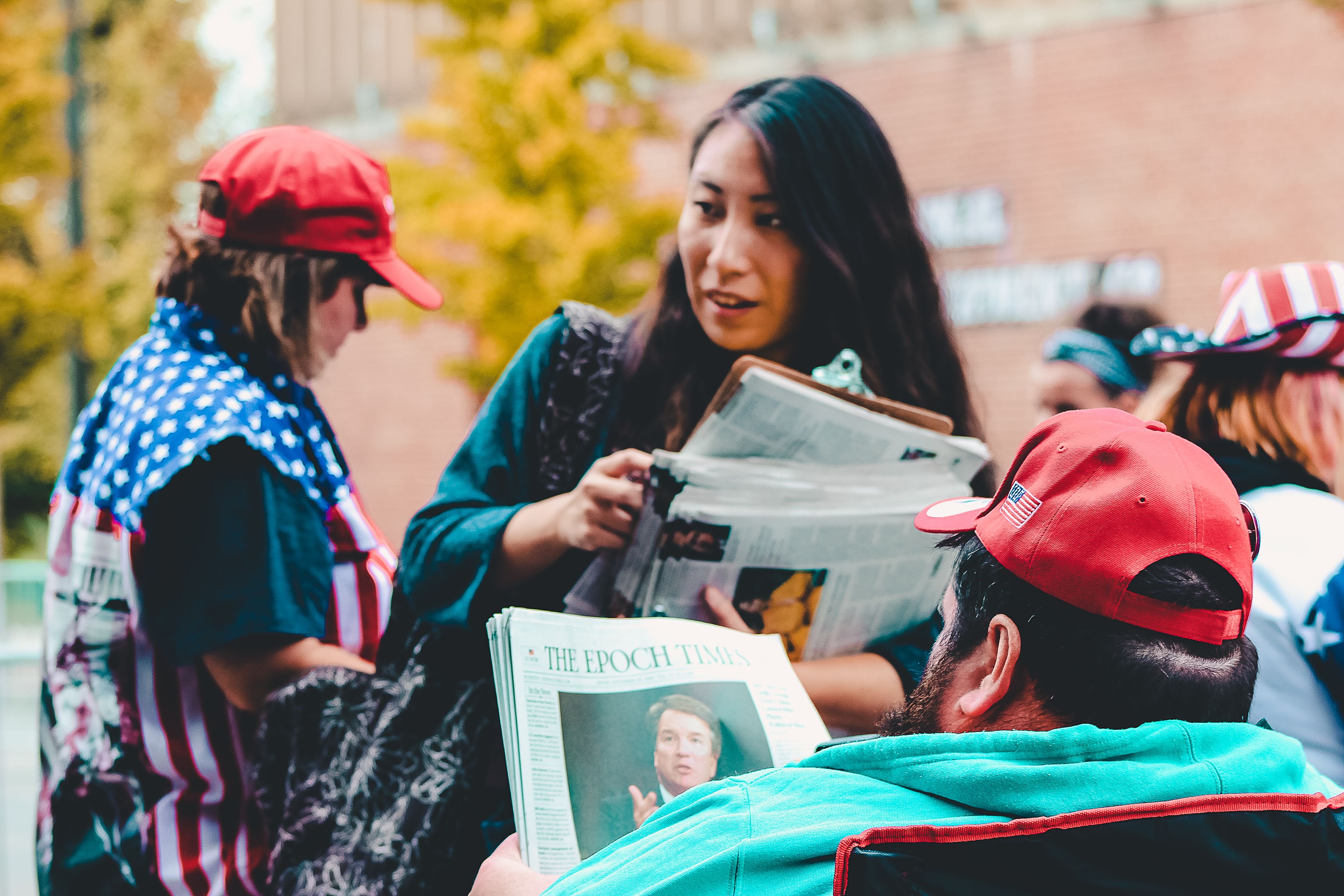 People reading newspapers together outdoors, illustrating public access to information and civic discussion