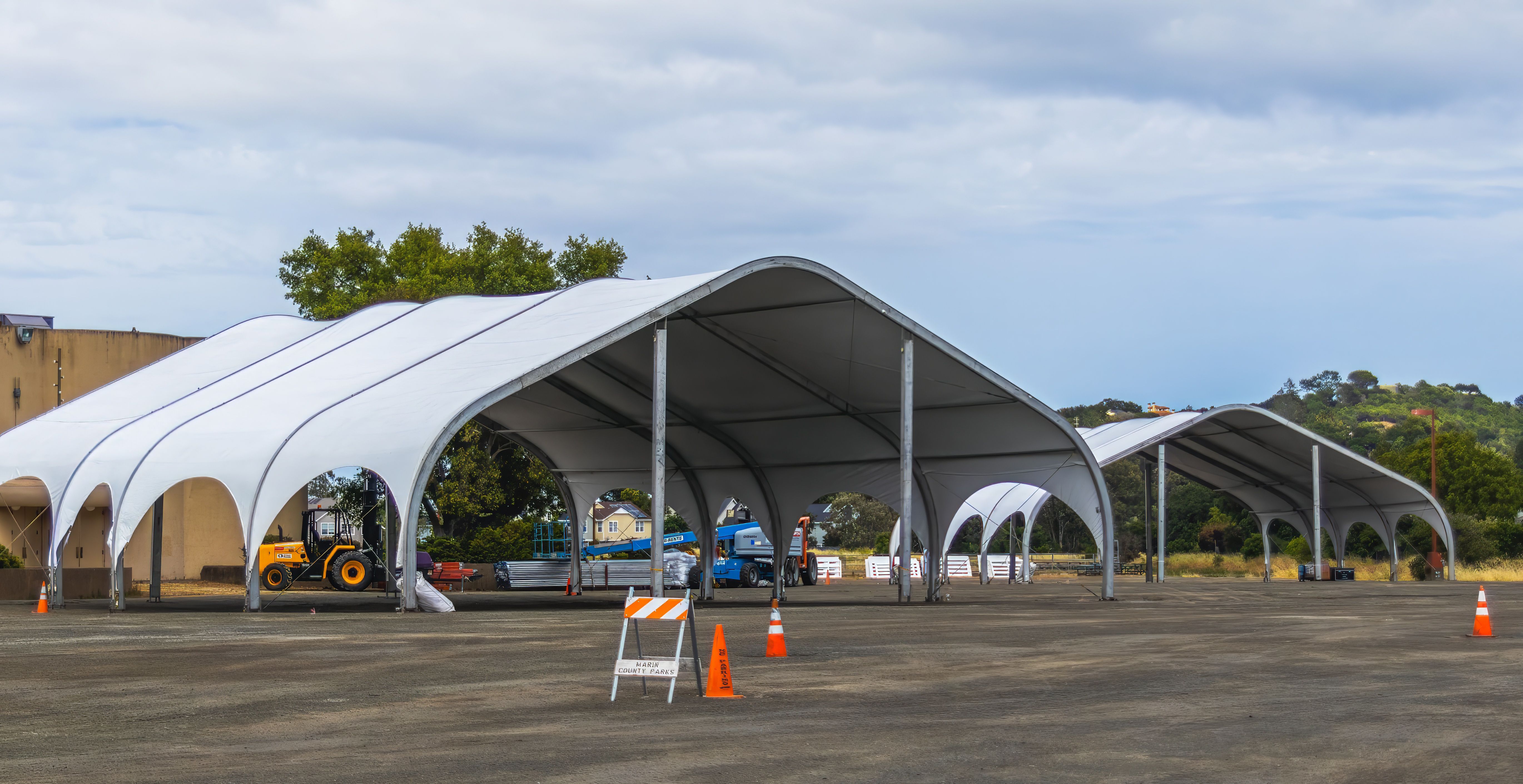 Large outdoor canopies set up in a field, illustrating weather shelter for live performance events.
